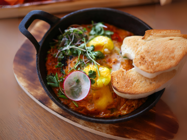 Delicious Shakshuka with Fresh Microgreens and Bread