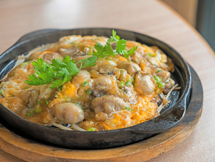 oyster-omelette-in-cast-iron-skillet-with-bean-sprouts-and-coriander-garnish