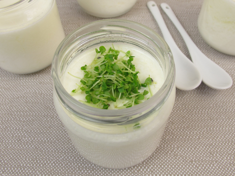 glass-jar-of-greek-yogurt-topped-with-fresh-green-microgreens-on-neutral-cloth-surface
